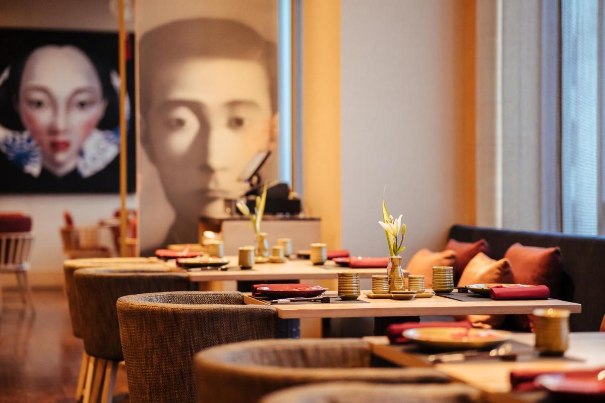 a room with tables and chairs and a portrait of a woman at Hyatt Regency Lucknow Gomti Nagar in Lucknow