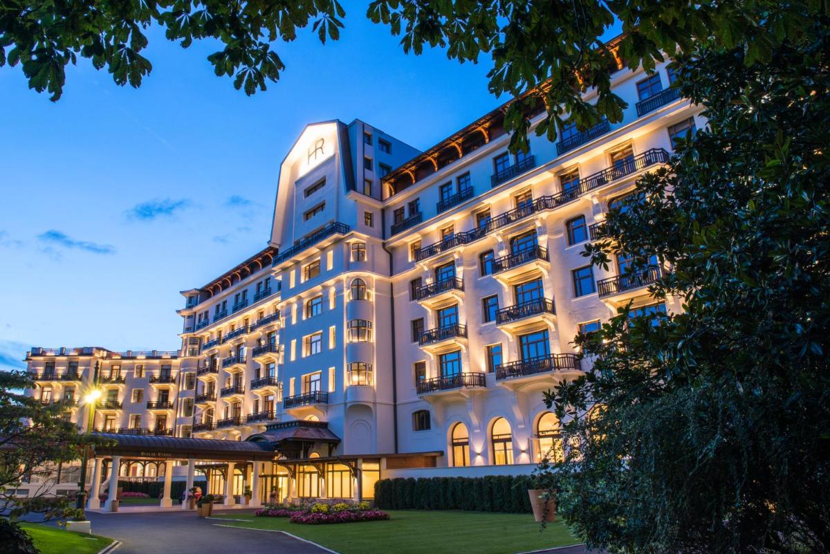 un grand bâtiment blanc éclairé dans l'établissement Hôtel Royal, à Évian-les-Bains