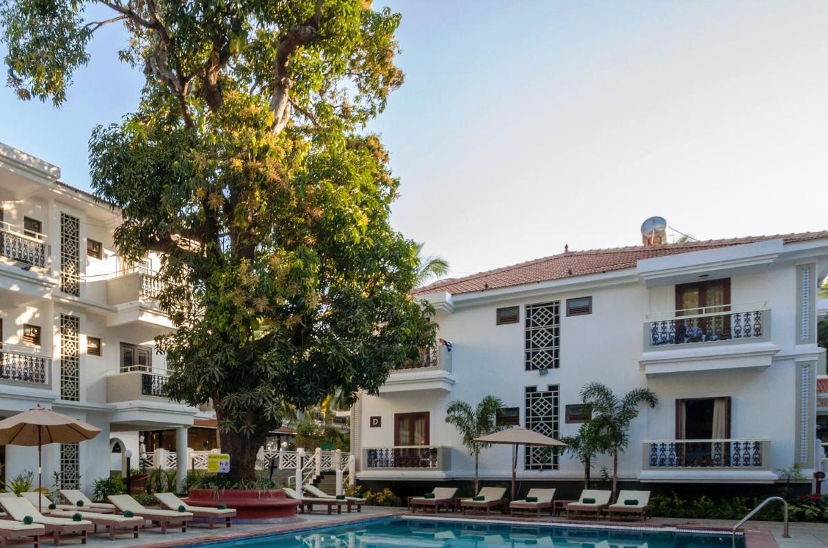 a hotel with a swimming pool in front of a building at Radisson Goa Candolim in Candolim
