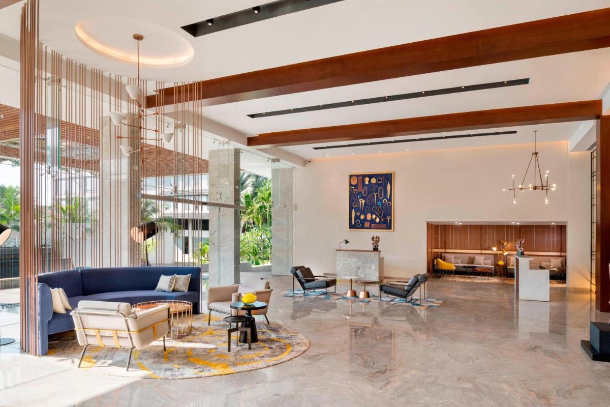 a living room with a blue couch and chairs at Le Meridien Goa, Calangute in Calangute a living room with a blue couch and chairs at Le Meridien Goa, Calangute in Calangute