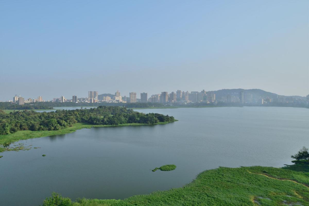 a large lake with a city in the background at The Westin Mumbai Powai Lake in Mumbai
