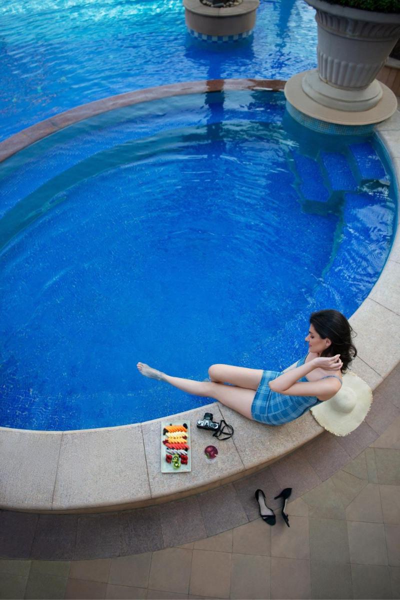 a woman laying on a float in a swimming pool at The Westin Mumbai Powai Lake in Mumbai