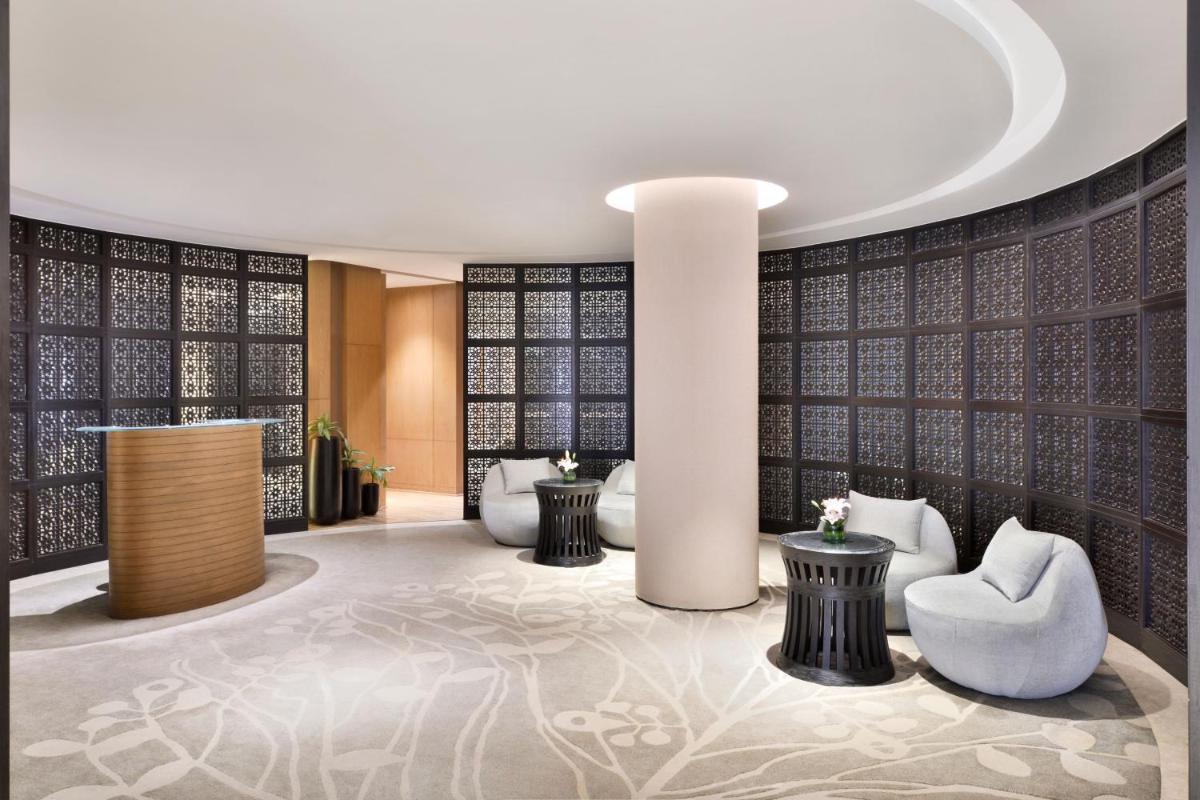a lobby with chairs and tables in a building at The Westin Mumbai Powai Lake in Mumbai