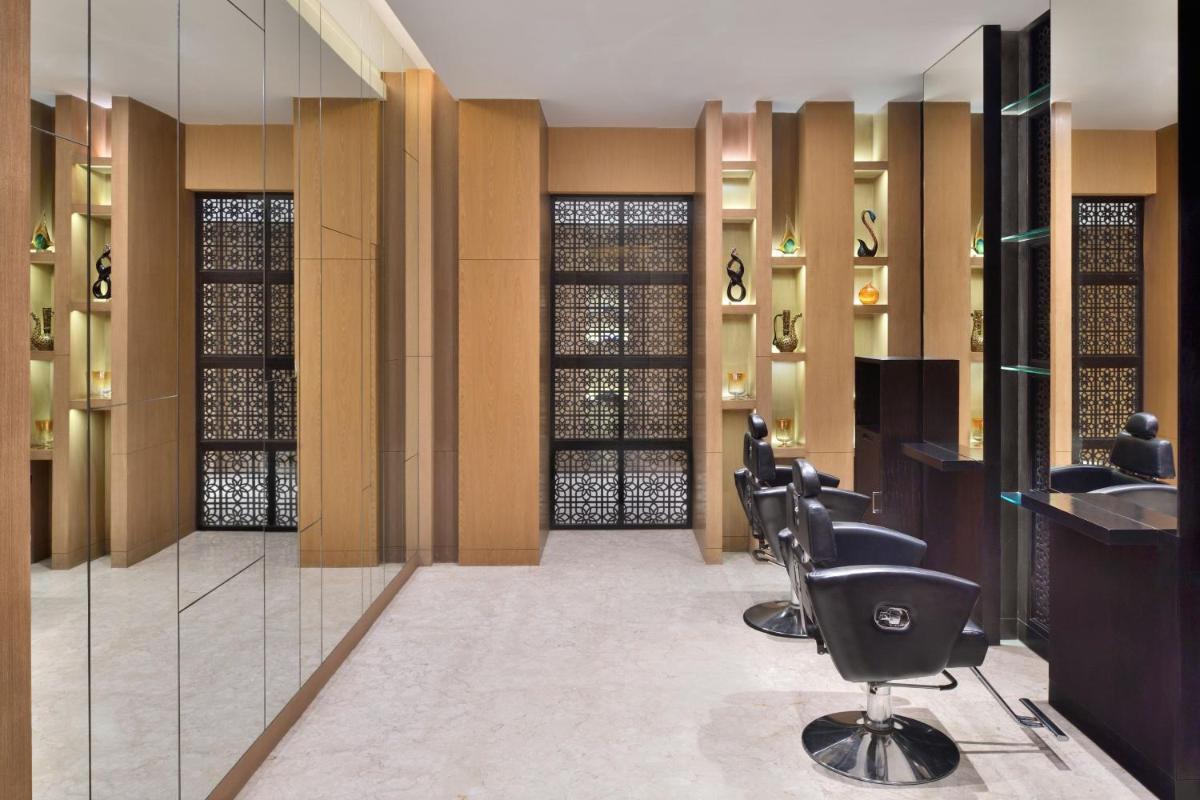 a hair salon with a row of chairs and mirrors at The Westin Mumbai Powai Lake in Mumbai