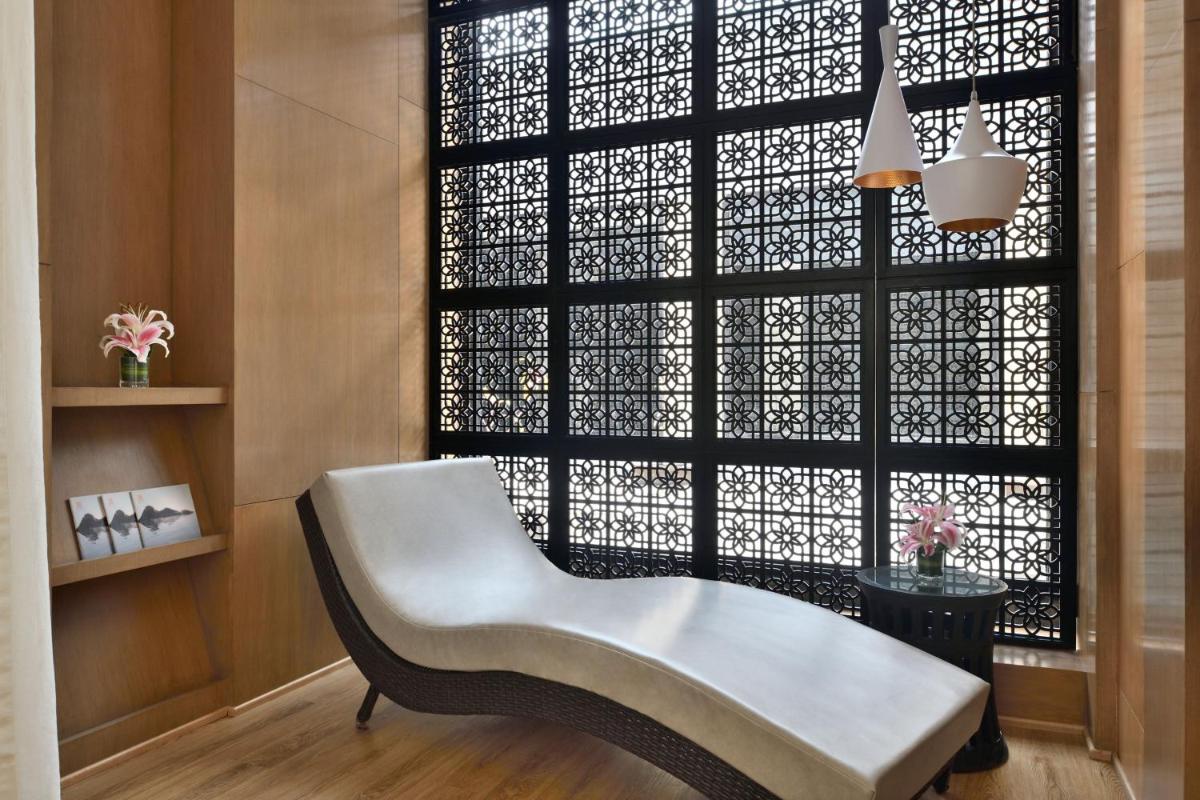 a white chair sitting in front of a window at The Westin Mumbai Powai Lake in Mumbai
