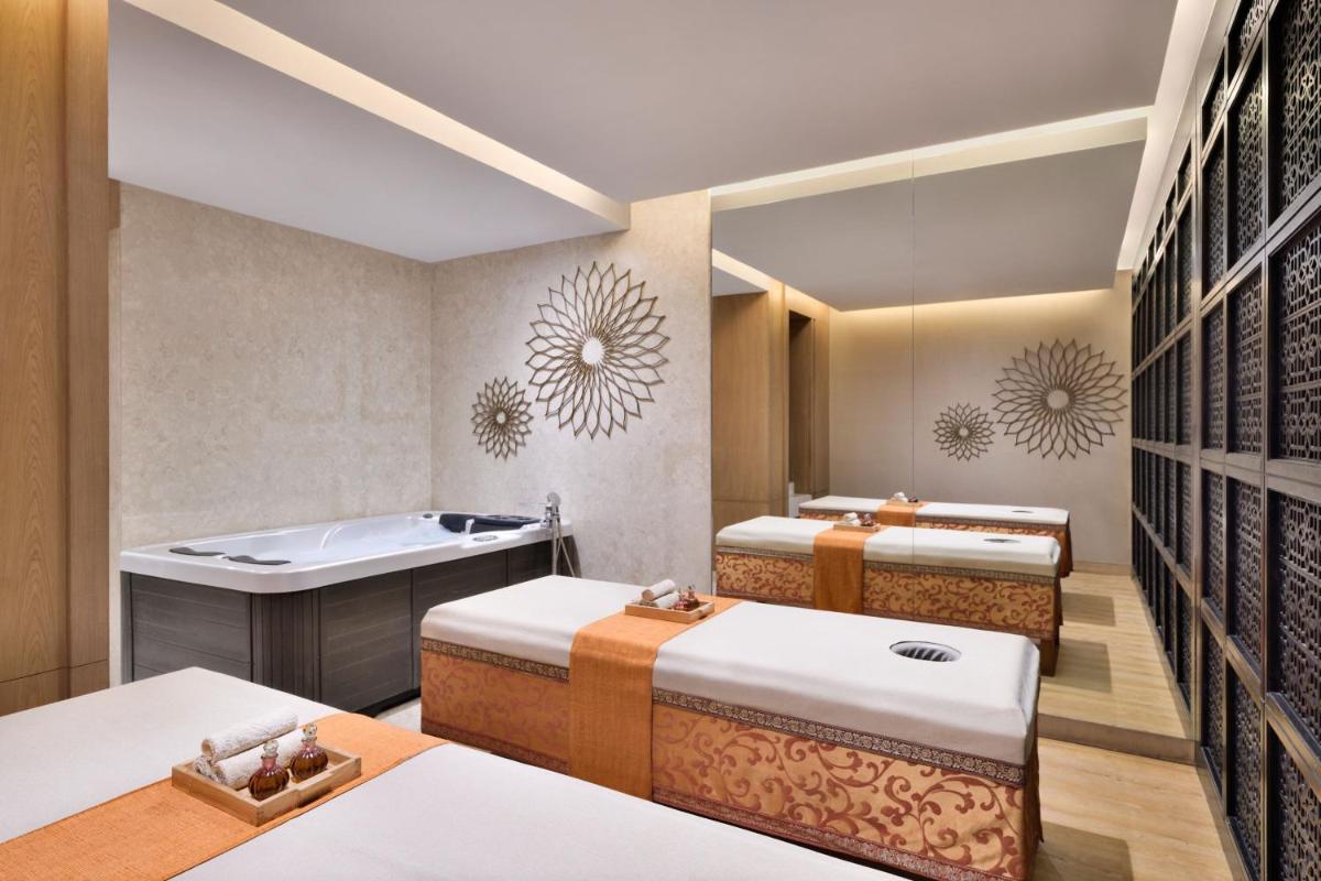 a spa room with three beds and a tub at The Westin Mumbai Powai Lake in Mumbai