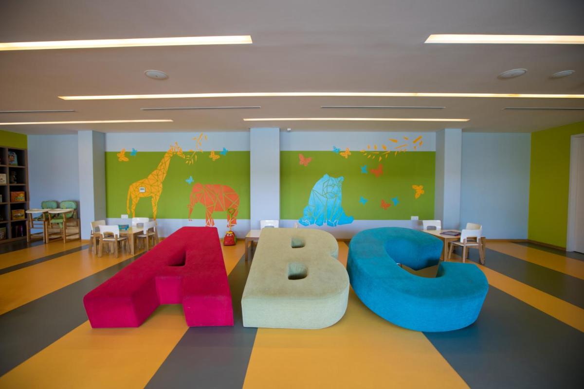 a childrens room with chairs and tables and a letter b at BLVD Club - Near BENGALURU AIRPORT in Bengaluru