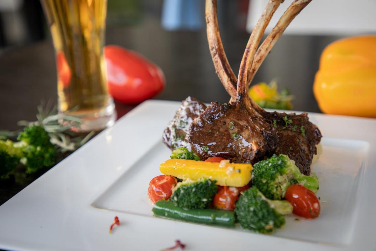 a plate of food with a piece of meat and vegetables at BLVD Club - Near BENGALURU AIRPORT in Bengaluru