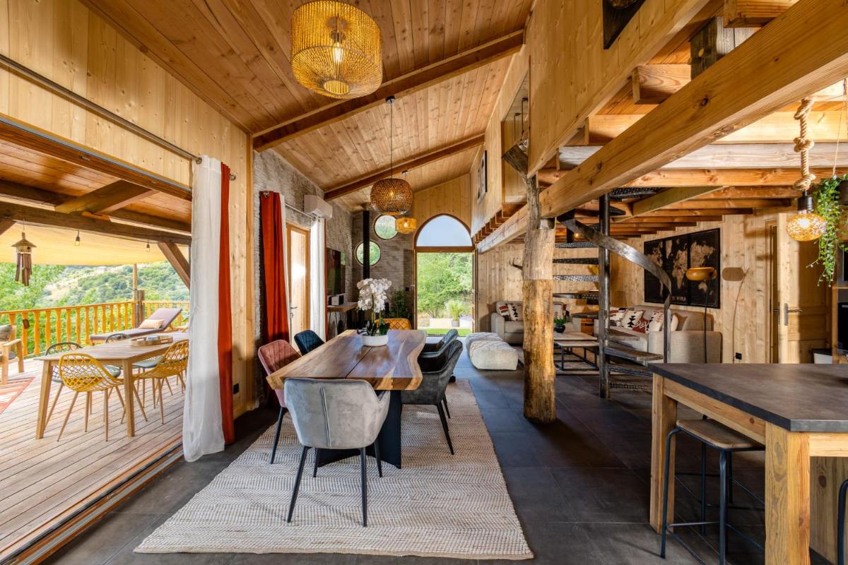 une cuisine et une salle à manger avec une table et des chaises dans l'établissement Domaine de Chalvêches Hôtel SPA 4*, à Faugères