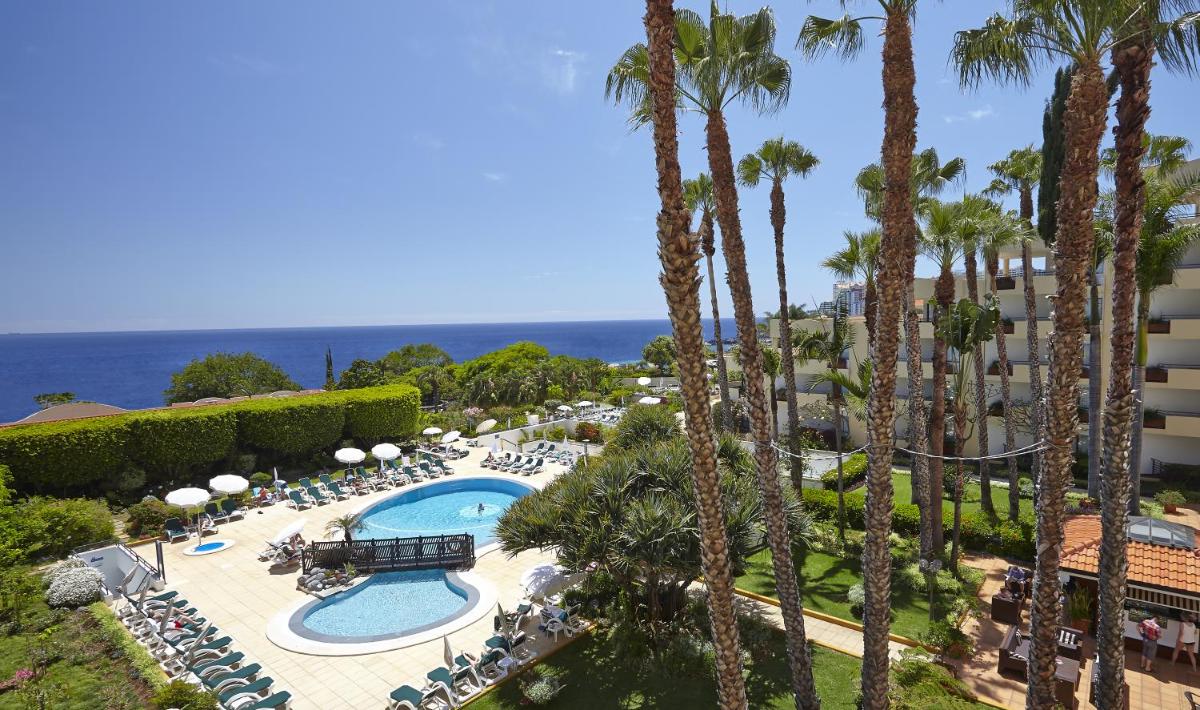 uma vista aérea de um resort com piscina e palmeiras em Suite Hotel Eden Mar - PortoBay no Funchal