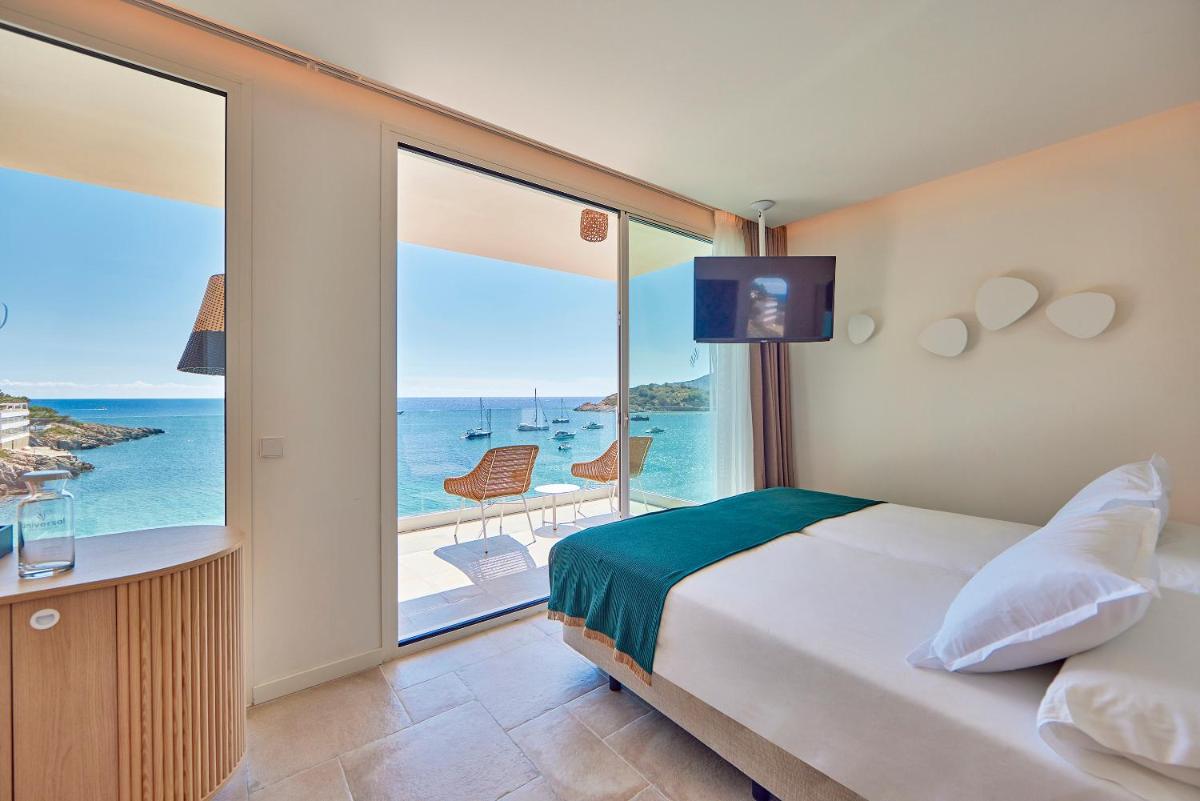Un dormitorio con una cama y vista al mar. en Universal Hotel Aquamarin, en Sant Elm 71 fotos más
