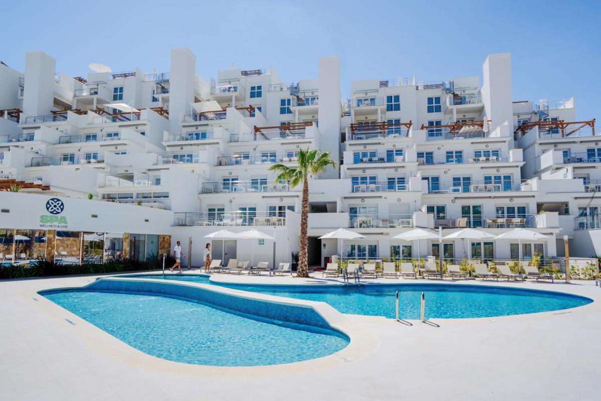 un hotel con piscina frente a un edificio en Dormio Resort Costa Blanca Beach & Spa, en El Campello