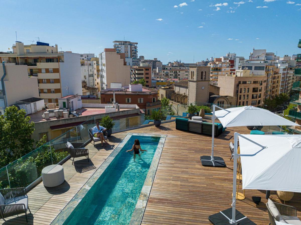 Una mujer está parada en una piscina en un edificio. en JS Palma Plaza, en Palma de Mallorca