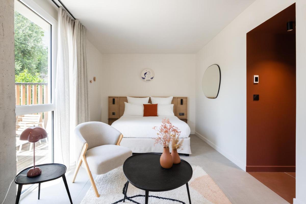 une chambre avec un lit, une table et une chaise dans l'établissement Les Elmes - Hôtel & Spa, à Banyuls-sur-Mer