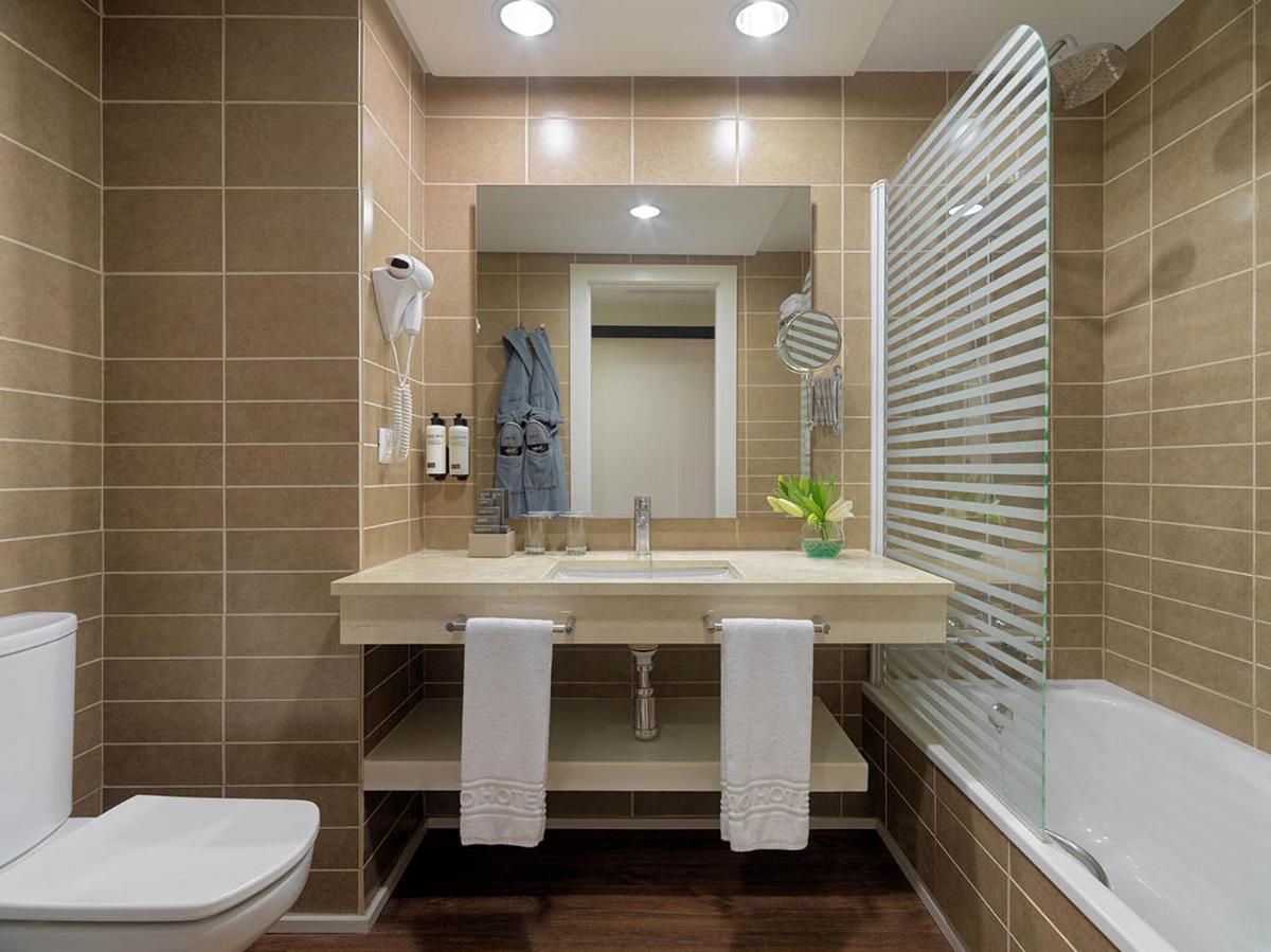 Un baño con lavabo, inodoro y bañera. en H10 Tindaya, en Costa Calma