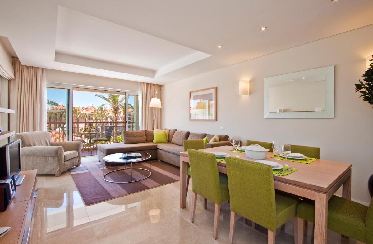 uma sala de jantar e sala de estar com mesa e cadeiras em As Cascatas Golf Resort & Spa em Vilamoura