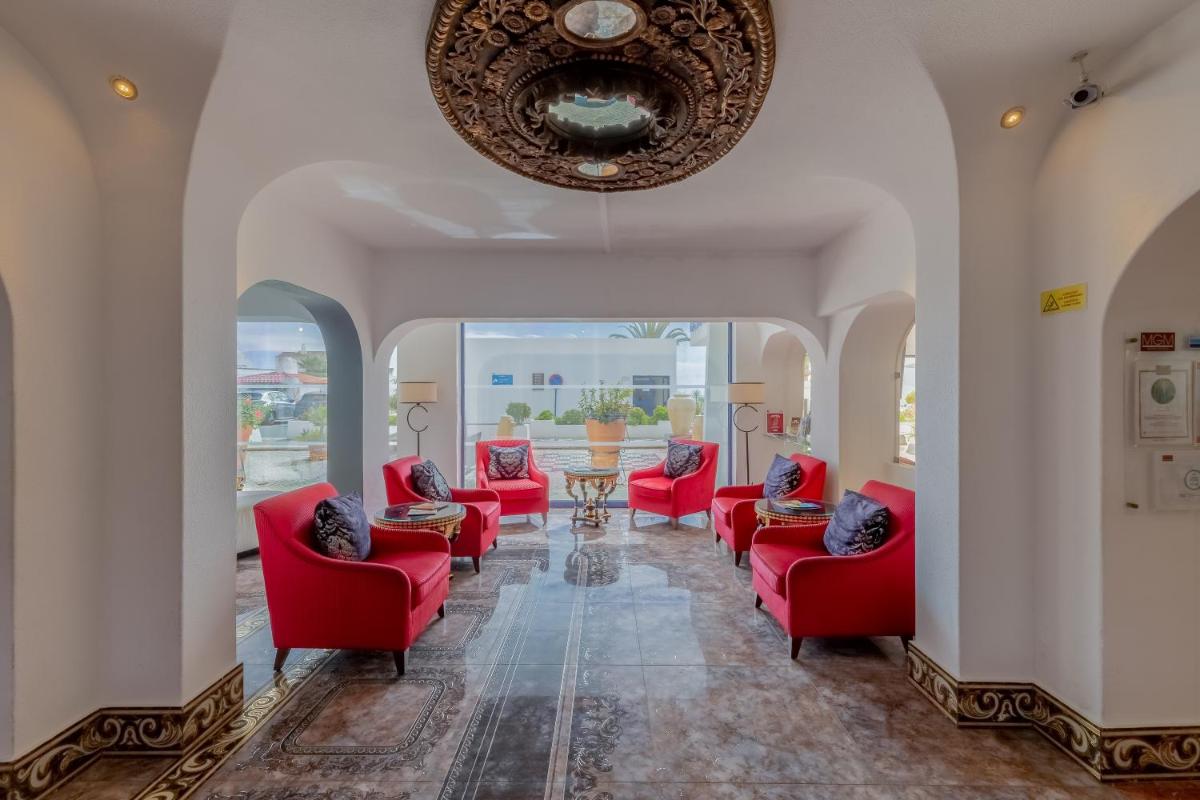 um quarto com cadeiras vermelhas e um tecto em Grand Muthu Oura View Beach Club em Albufeira