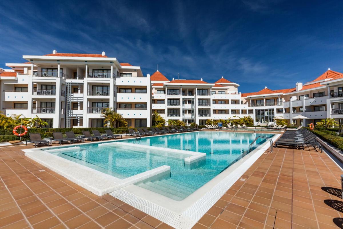 uma piscina em frente a alguns edifícios de apartamentos em As Cascatas Golf Resort & Spa em Vilamoura