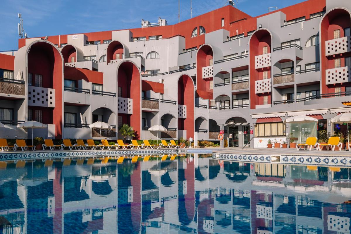 um hotel com piscina em frente a um prédio em Muthu Oura Praia Hotel em Albufeira mais 90 fotografias