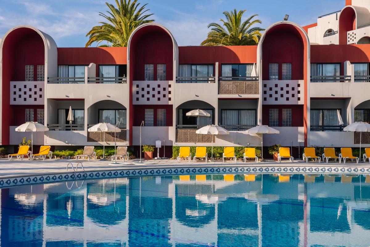 um hotel com piscina em frente a um prédio em Muthu Oura Praia Hotel em Albufeira