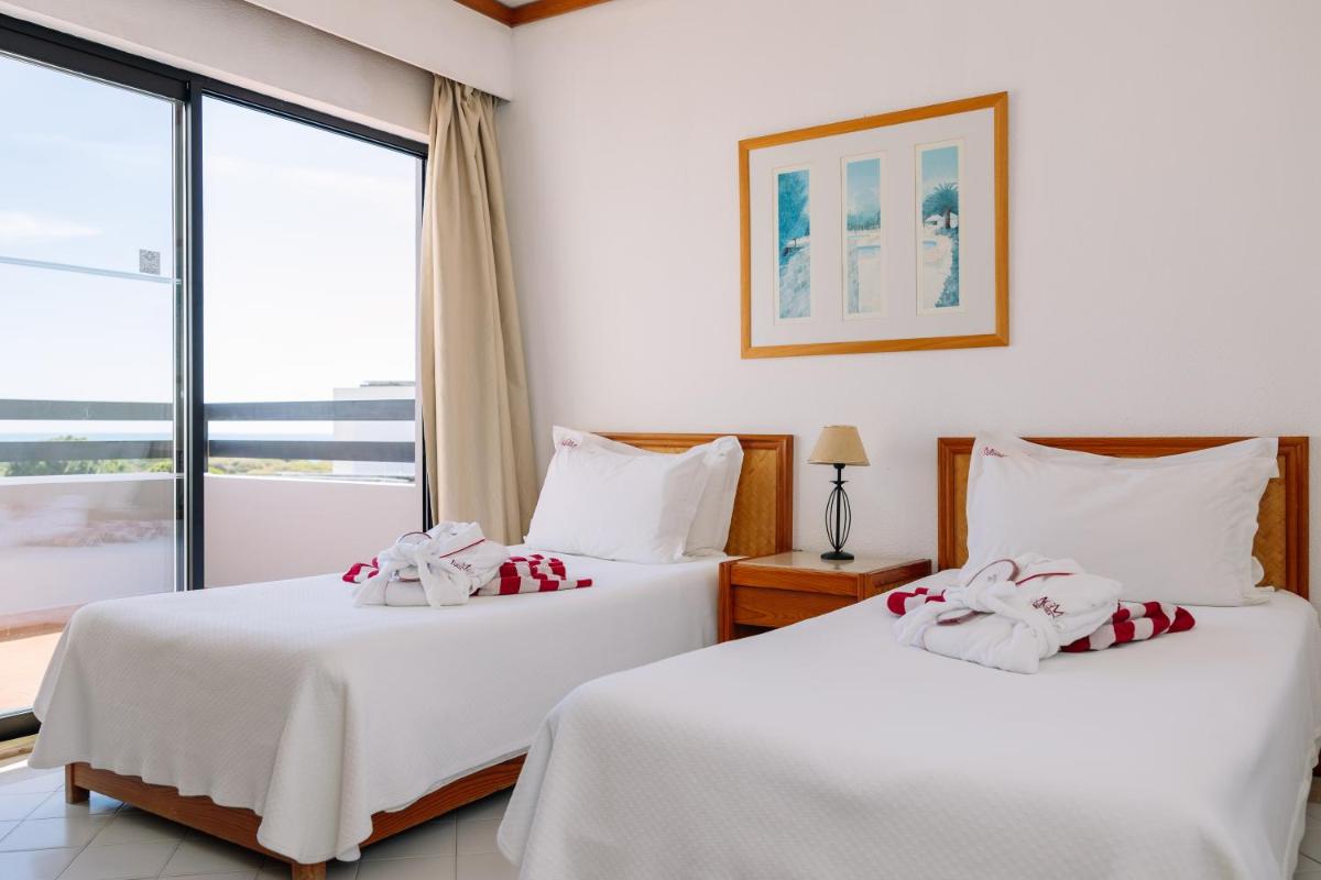 Uma cama ou camas num quarto em Muthu Oura Praia Hotel