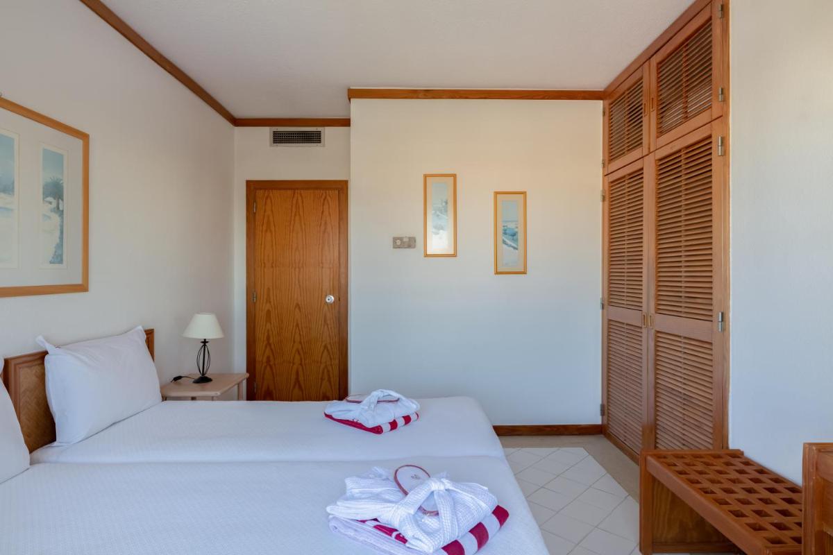 Uma cama ou camas num quarto em Muthu Oura Praia Hotel