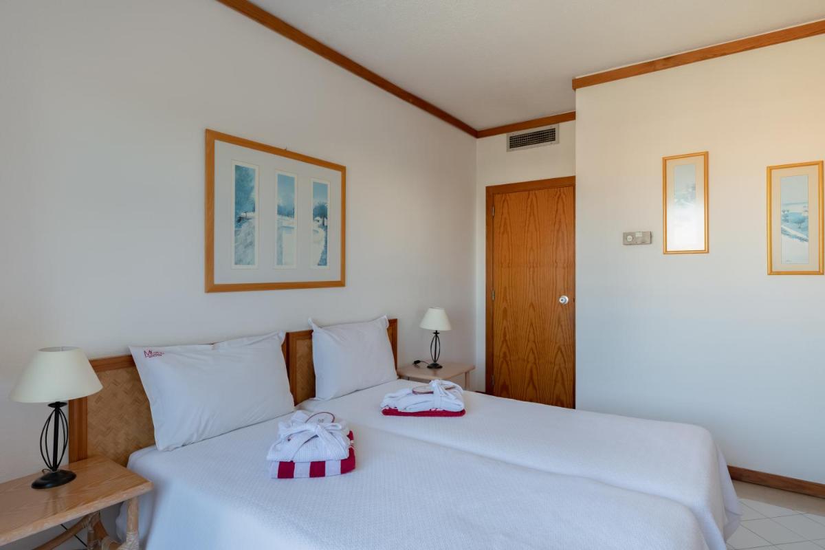 Uma cama ou camas num quarto em Muthu Oura Praia Hotel