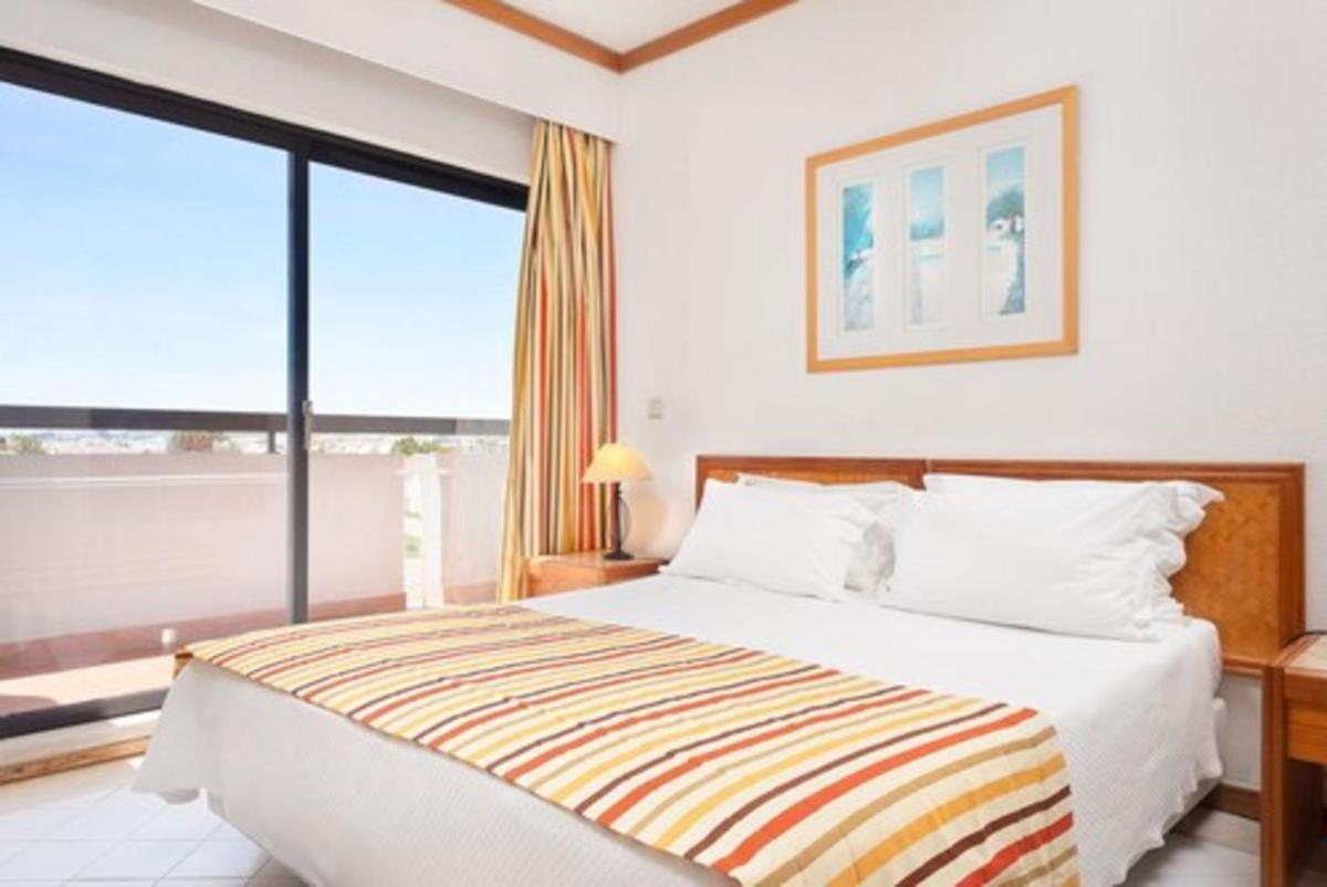 Uma cama ou camas num quarto em Muthu Oura Praia Hotel