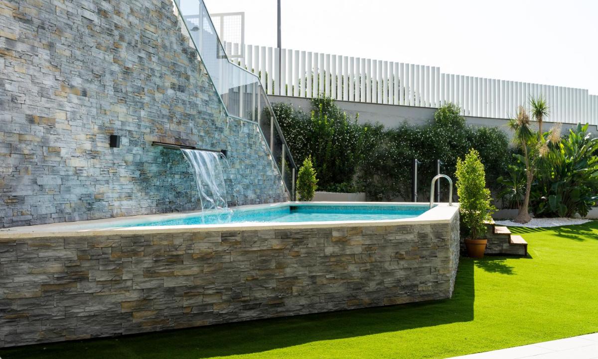 Una piscina con una fuente de agua en un patio. en AZZ Valencia Congress Hotel & Spa, en Paterna