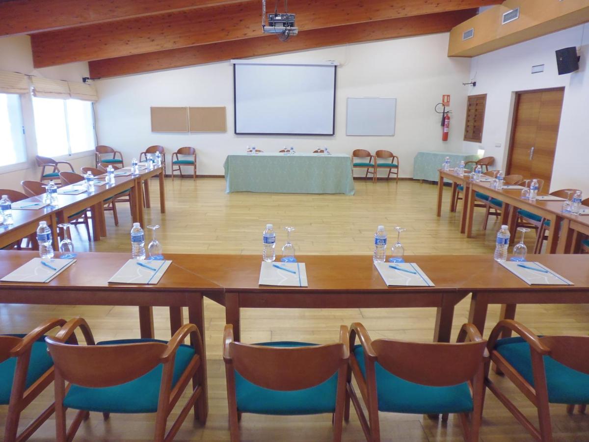 Habitación grande con mesas, sillas y una pantalla. en Grupotel Mallorca Mar, en Cala Bona 38 fotos más