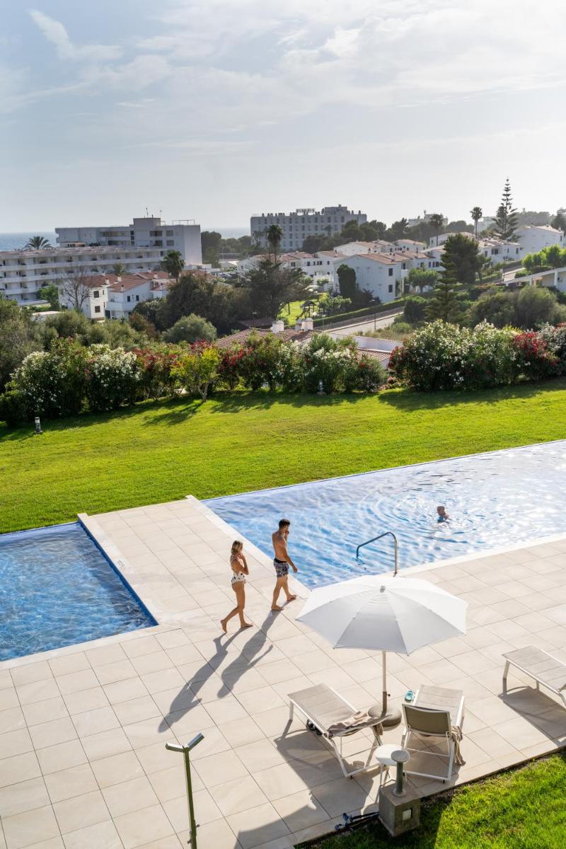 Dos niños caminando junto a una piscina con una sombrilla en Seth 55 Santo Tomas, en Santo Tomás