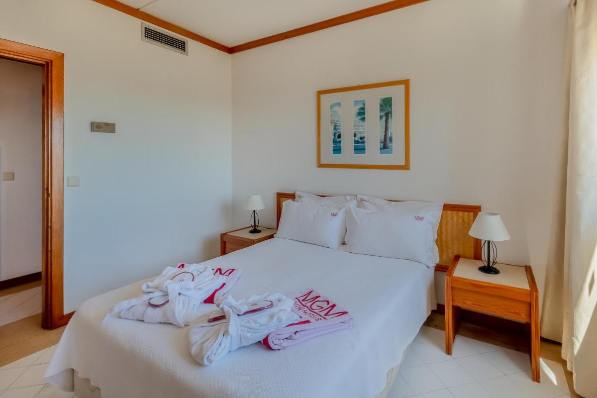 Uma cama ou camas num quarto em Muthu Oura Praia Hotel