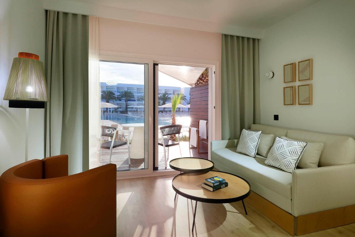 una sala de estar con un sofá y una mesa en Grand Palladium Select Palace Ibiza - All Inclusive, en Playa d'en Bossa