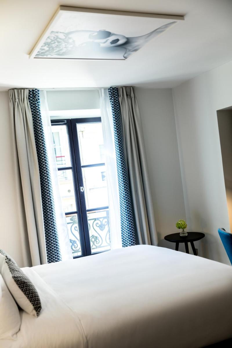 une chambre avec un lit et une fenêtre dans l'établissement Renaissance Paris Vendome Hotel, à Paris