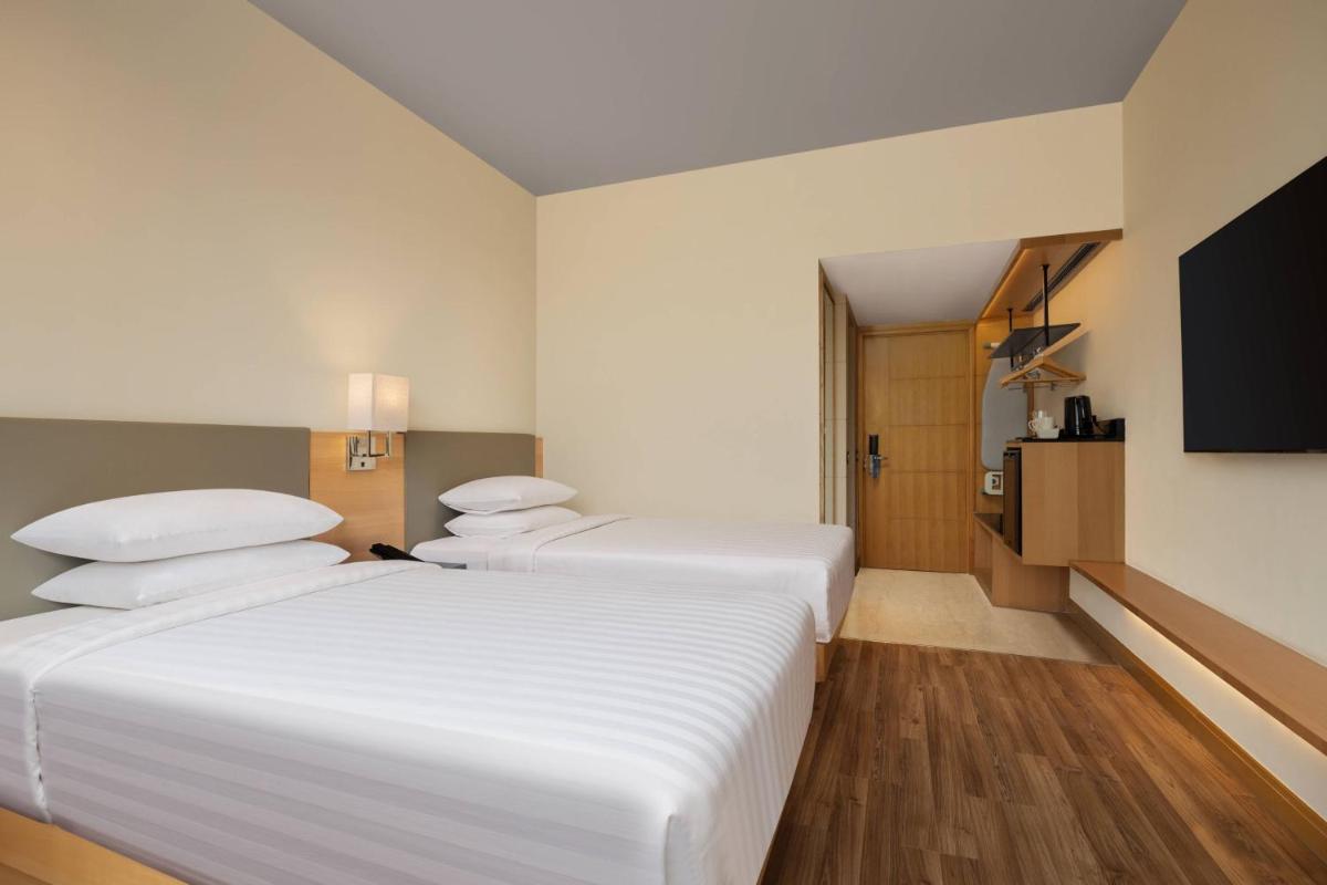a hotel room with two beds and a flat screen tv at Fairfield by Marriott Jaipur in Jaipur