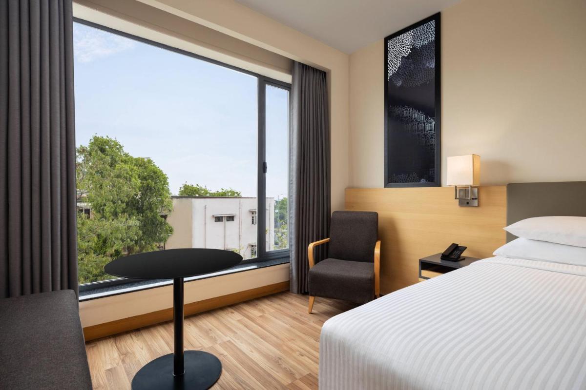 a hotel room with a bed and a desk and a window at Fairfield by Marriott Jaipur in Jaipur