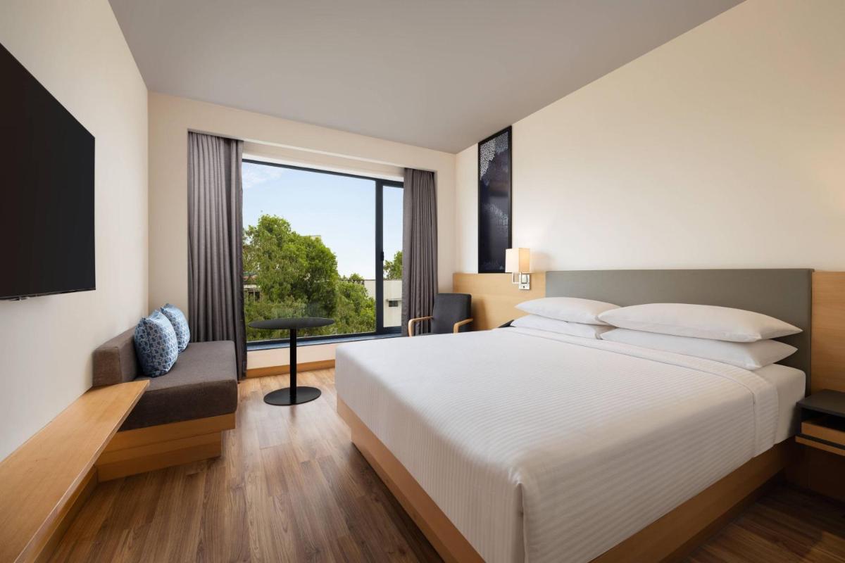 a bedroom with a large bed and a large window at Fairfield by Marriott Jaipur in Jaipur