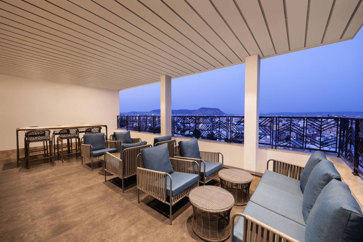 a waiting room with couches and chairs and a large window at Fairfield by Marriott Jaipur in Jaipur