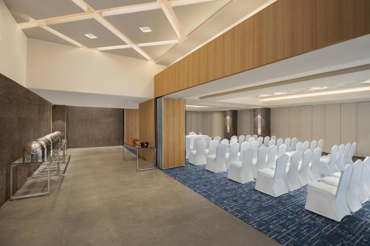 a conference room with white chairs and a podium at Fairfield by Marriott Jaipur in Jaipur