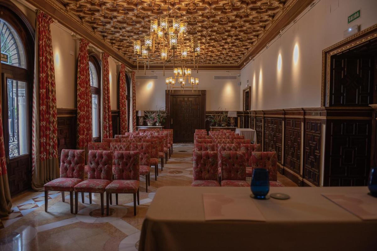 una sala de conferencias con sillas y una lámpara de araña en Hotel Casa Palacio María Luisa, en Jerez de la Frontera