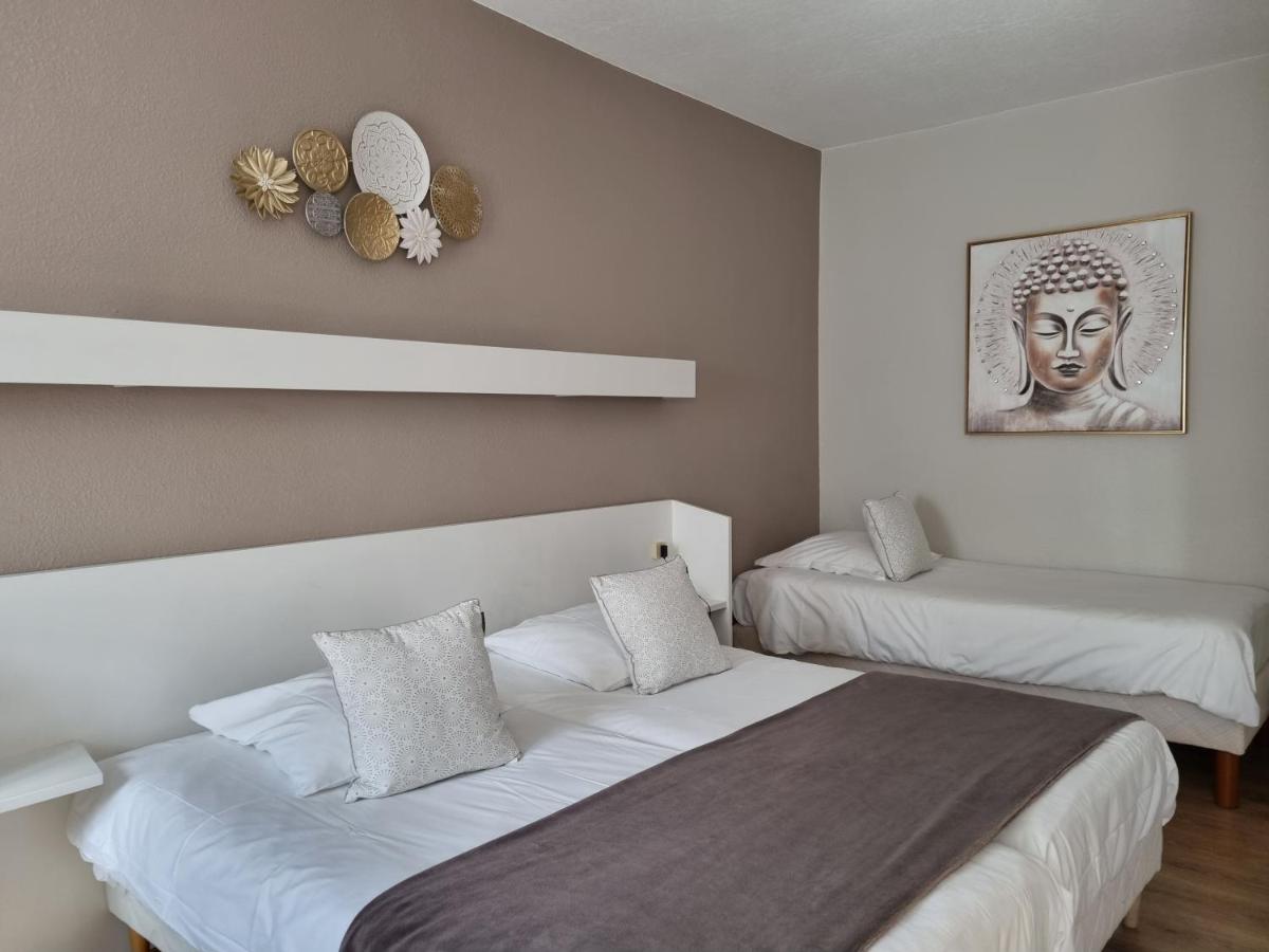 - une chambre avec 2 lits et une statue de tête dans l'établissement Logis Hôtel Restaurant De La Poste et SPA de Montagne, à Le Bonhomme