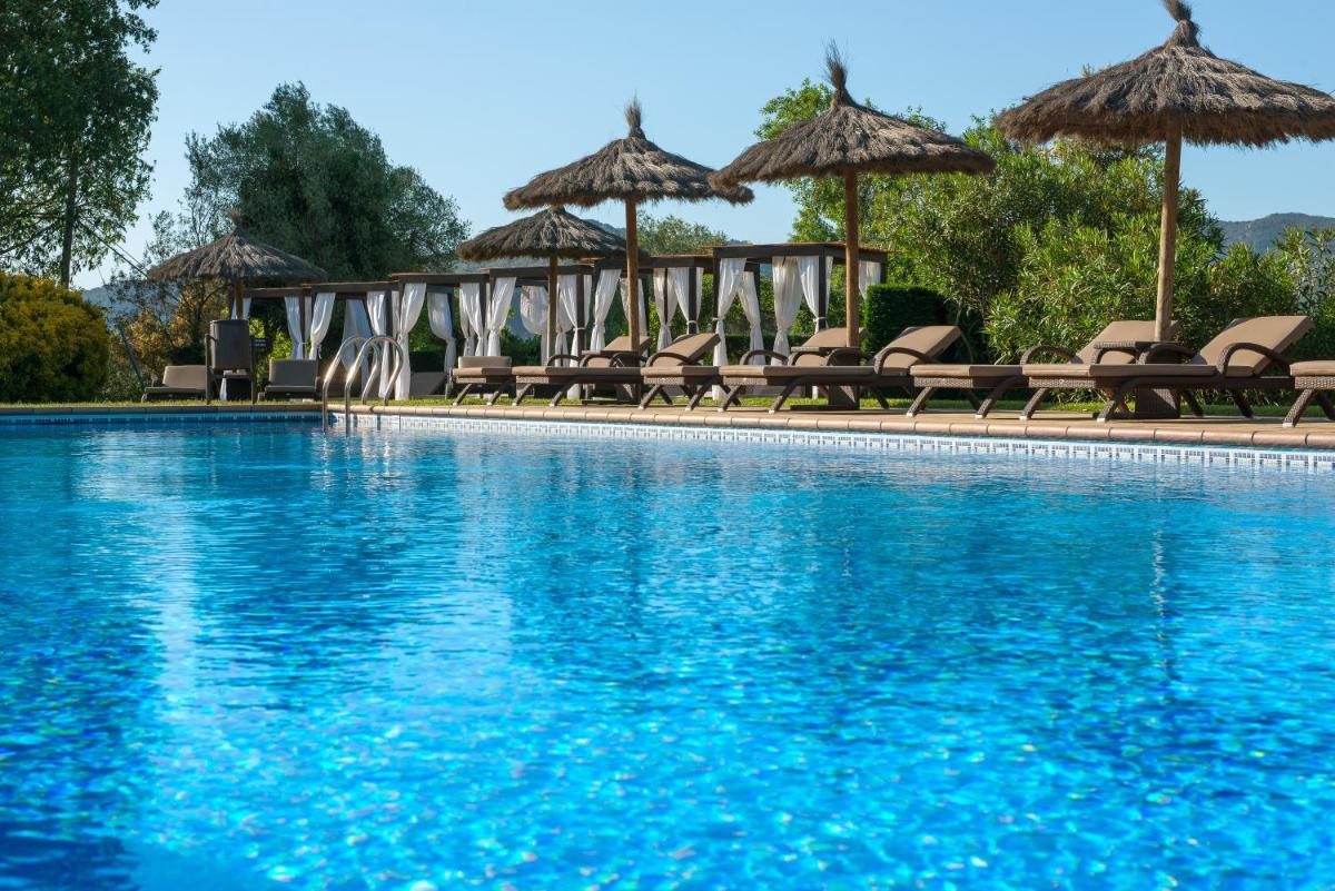 una piscina con sillas y sombrillas en Mas Tapiolas, en Santa Cristina d'Aro