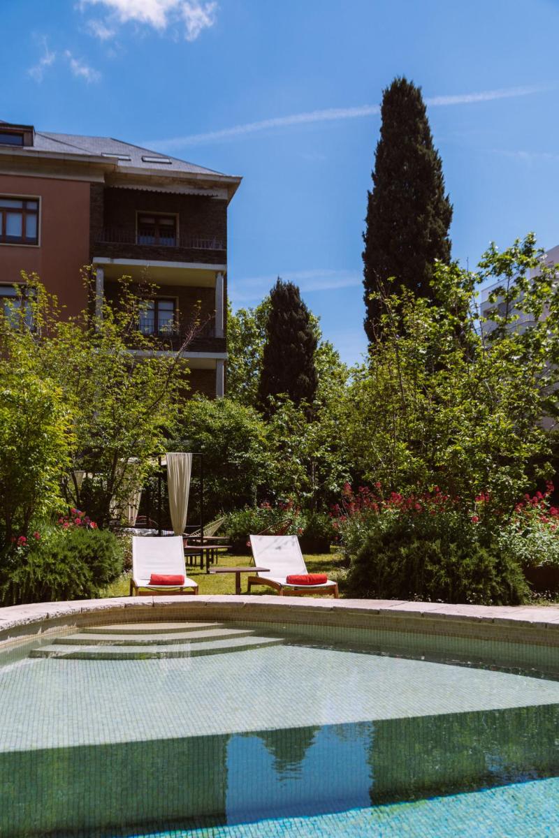 una piscina con dos sillas y una casa en Primero Primera, en Barcelona
