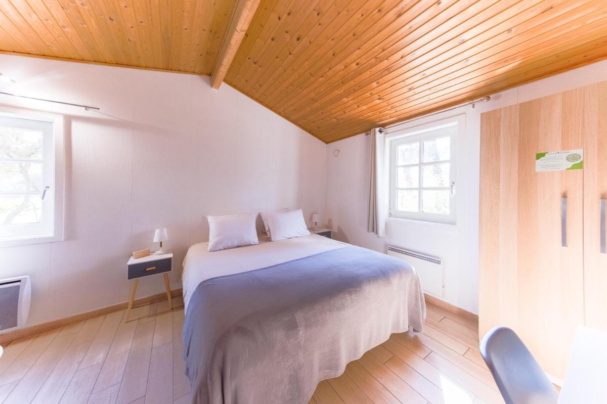 une chambre avec un lit et un plafond en bois dans l'établissement La Villa Vicha, The Originals Relais, à Aubais 124 autres photos
