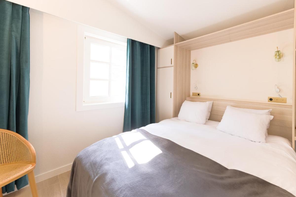 Un ou plusieurs lits dans un hébergement de l'établissement La Villa Vicha, The Originals Relais