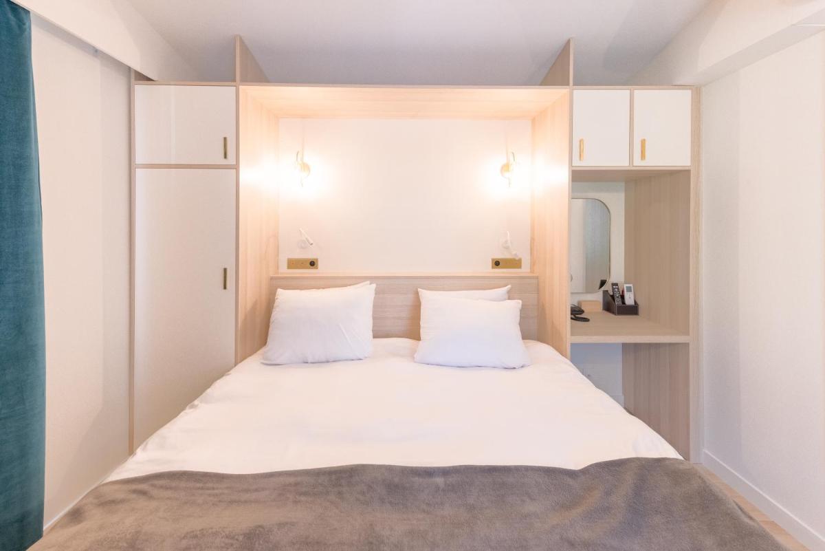 Un ou plusieurs lits dans un hébergement de l'établissement La Villa Vicha, The Originals Relais