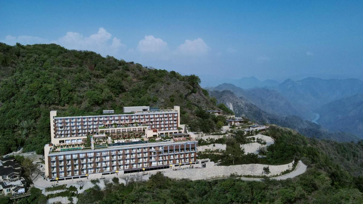 a hotel on top of a mountain with a river at The Westin Resort & Spa Himalayas in Rishīkesh