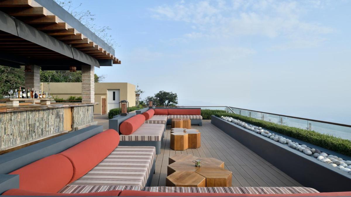 a rooftop bar with benches and tables on a building at The Westin Resort & Spa Himalayas in Rishīkesh