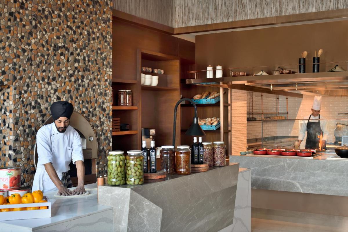 a man standing in a kitchen preparing food at The Westin Resort & Spa Himalayas in Rishīkesh