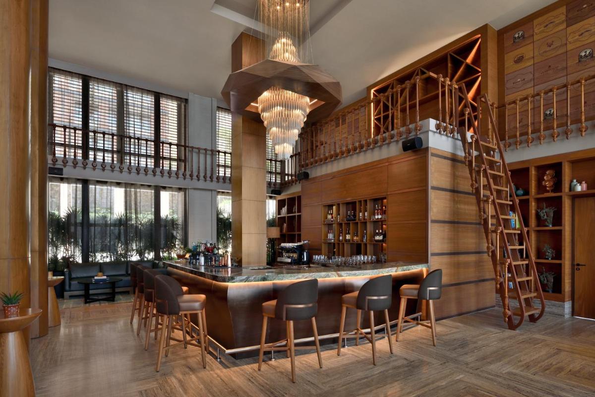 a bar in a restaurant with chairs and tables at The Westin Resort & Spa Himalayas in Rishīkesh